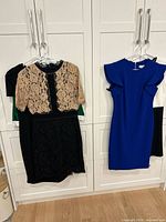 Five dresses on hangers; blue, lace, green, white visible