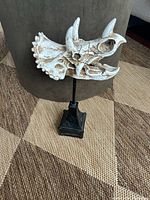 Front angled view of triceratops skull figurine on stand