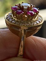 Side view showing raised cluster, gold-tone finish, stones, shank