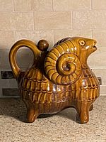 Full view of brown glazed ceramic ram decanter with stopper
