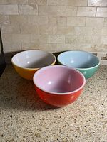 Three primary-colored Pyrex mixing bowls on countertop