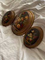 Three oval floral plaques side view