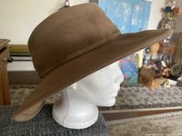Left side view of Tilley wide-brim brown hat on mannequin
