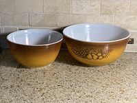 Both Pyrex bowls side by side showing size difference and exterior design