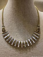 Full view of necklace on bust showing bib design and clasp ends
