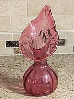 Front view of cranberry handblown glass vase showing shape and color
