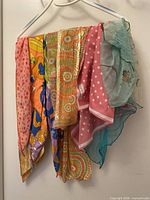 All six scarves hanging on hanger showing full patterns and colors