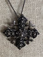 Front view of silver floral cross pendant on chain