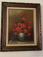 Full view of framed oil painting showing roses in vase, carved wood frame visible