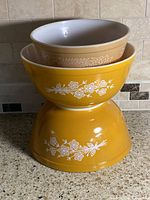 Three nested Pyrex bowls showing colors and decals