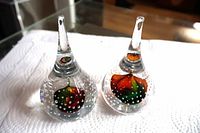 Both teardrop glass paperweights side by side