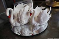 Front view of both Goebel porcelain swans on mirrored surface