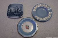 Three small dishes grouped: Wedgwood round with relief, Royal Bayreuth scalloped with floral, Kronborg square scenic