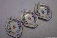 Three Schumann Dresden porcelain ashtrays side by side
