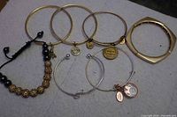 All seven bracelets and two charms laid out