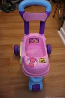 Front view of pink stroller-style push walker