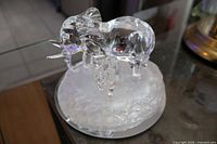 Front left view of clear frosted glass adult elephant and calf on frosted base