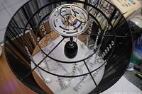 Top view of chandelier showing flush-mount plate, wiring, crystal strands, and black silk shade interior