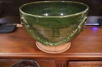 Front view of green glazed terracotta planter with swag handles