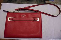 Front view of red Guess 1981 purse with chain and leather strap