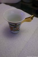 Side view showing Garden of Papillon pattern and gold wing handle