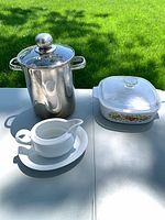Group shot of stock pot with lid, CorningWare casserole with lid, gravy boat on saucer