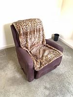 Brown microfiber recliner chair with leopard print faux fur throw draped over backrest