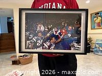 Front view of framed Patriots photograph held at chest height