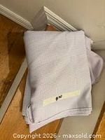 Folded lavender gingham cotton fabric on floor