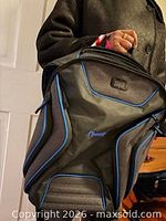 Front view of black Ogio backpack showing blue piping and brand logo