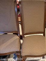 Front view of two chairs showing upholstery and wood frame