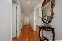 Hallway view showing ornate oval gilt wood wall mirror with clear glass