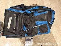 Top view of blue/black rolling duffel showing exterior pockets and telescoping handle housing