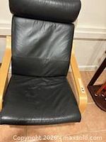 Front view of black leather Poäng-style armchair with headrest