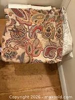 Folded paisley cotton blend curtain panel on floor corner