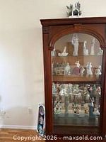 Front view of Pulaski mahogany curio cabinet with glass door and interior shelves