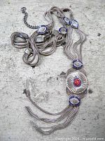 Full view of necklace showing triple strands, five medallions, clasp and extender