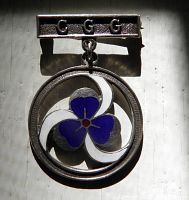 Front view showing C G G bar and enamel trefoil pendant