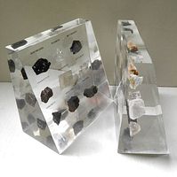 Front view showing both lucite blocks with visible mineral specimens and printed labels
