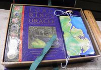 Open box showing guidebook, card deck, ribbon