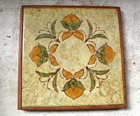 Front view square ceramic tile trivet with floral motif in wooden frame