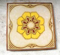 front view of framed ceramic trivet tile showing floral design and frame