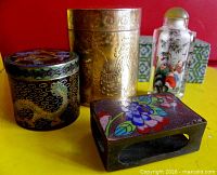 Group view showing all four items: two lidded containers, enamel match striker, glass snuff bottle