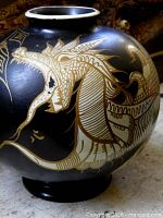 Full view of black glazed vase showing dragon design and neck