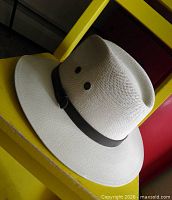 Hat exterior showing off-white straw weave, brim and brown band
