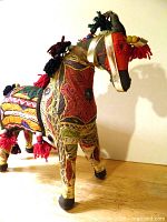 Right side view of embroidered horse showing colours, tassels and overall condition