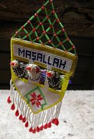 Front view showing Masallah text, three birds, lattice roof, fringe