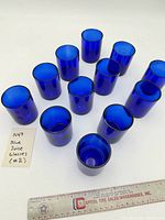 All 12 blue glasses with ruler for scale
