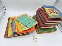 Stacked hardcovers and separate pile of softcover booklets showing quantity