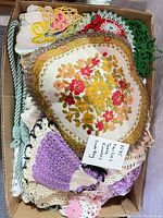 Box containing mixed crocheted and embroidered doilies, small motifs and decorative cord